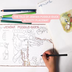 May include: A white paper activity placemat featuring black line art illustrations of Jemima Puddle-Duck, a fox, and a maze. The text reads THE TALE OF JEMIMA PUDDLE-DUCK ACTIVITY PLACEMAT, JEMIMA PUDDLE-DUCK, Egg Symmetry, and I SPY. Four coloured pencils are included.