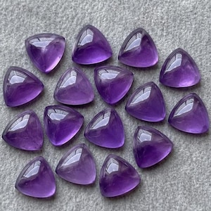 Könnte beinhalten: Eine Sammlung von vierzehn polierten, dreieckigen violetten Amethyst-Edelsteinen. Jeder Stein weist eine glatte, facettierte Oberfläche mit glänzendem Finish auf und zeigt verschiedene Schattierungen von tiefem Violett und durchscheinenden Tönen.