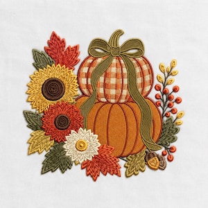 May include: An embroidery design featuring two stacked pumpkins, one with an orange and white gingham pattern and one solid orange, tied with a green ribbon. The pumpkins are surrounded by sunflowers, red and green leaves, and orange berries.