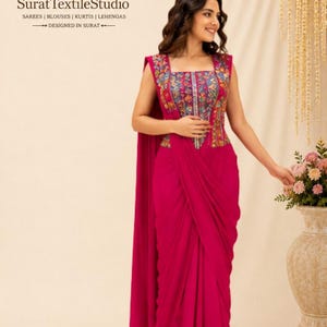 Peut inclure: Une robe sans manches fuchsia vif avec une encolure carrée et un corsage orné d'un motif floral et géométrique multicolore. La jupe présente une silhouette drapée style portefeuille avec un long pan fluide tombant depuis l'épaule.