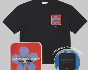 May include: A black short-sleeve t-shirt featuring a square red patch with a blue flower and the text MOODULAR WEAR SYSTEM. A separate red patch with the same flower design and a black base patch with the text OPEN TO MOOD are also displayed.