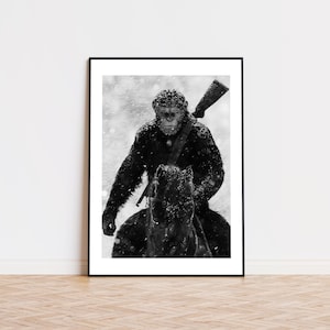 May include: A black and white framed wall art print depicting a primate riding a horse through a snowstorm. The primate has a rifle slung over its shoulder and is covered in light snow. The image is presented in a simple black frame.