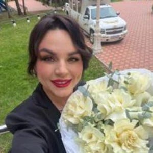 K&ouml;nnte beinhalten: Ein Blumenstrau&szlig; aus wei&szlig;en Rosen mit gr&uuml;nen Eukalyptusbl&auml;ttern, eingewickelt in wei&szlig;es Papier. Die Blumen sind in einem runden B&uuml;ndel angeordnet und zeigen zahlreiche bl&uuml;hende Bl&uuml;tenbl&auml;tter sowie gr&uuml;ne Blattakzente im gesamten Arrangement.