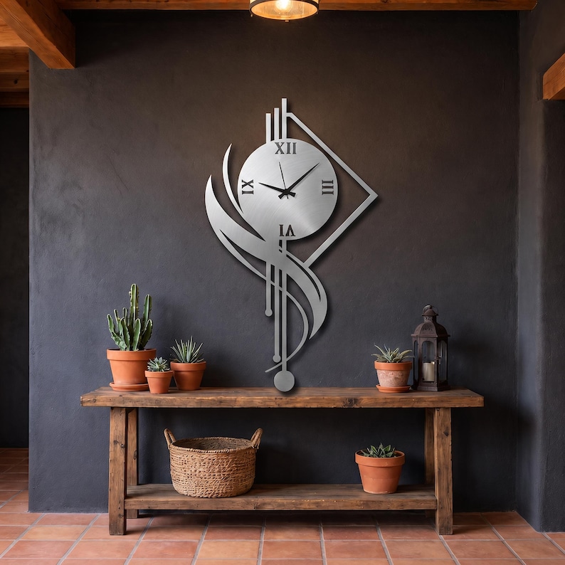 K&ouml;nnte beinhalten: Eine silberfarbene Wanduhr aus Metall mit einem runden Zifferblatt, schwarzen r&ouml;mischen Ziffern und d&uuml;nnen schwarzen Zeigern. Die Uhr ist in einen geometrischen Rahmen mit vertikalen Linien, einer rautenf&ouml;rmigen Kontur und einem geschwungenen Akzent integriert.