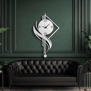 K&ouml;nnte beinhalten: Eine wei&szlig;e Wanduhr mit einem runden Zifferblatt, schwarzen r&ouml;mischen Ziffern und Zeigern, montiert auf einem geometrischen Rahmen mit vertikalen Linien und einem geschwungenen, blattartigen Element, das in einem Pendelgewicht endet.
