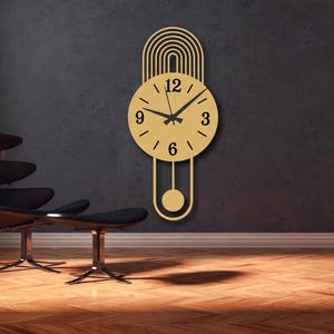 May include: A gold-colored wall clock with a circular face, black hands, and black numerals at the 3, 6, 9, and 12 positions. The clock features an arched top design with concentric lines and a pendulum extending from the bottom of the circle.