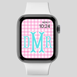 May include: A white Apple Watch with a pink and white gingham watch face. The watch face displays the date, time, and the monogram "DMR" in a turquoise blue font.