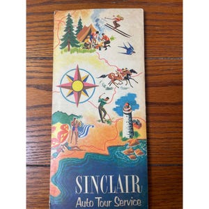 May include: A vintage Sinclair Auto Tour Service brochure featuring colorful illustrations of outdoor activities including skiing, camping, horseback riding, golfing, and beach scenes, centered around a large compass rose and a lighthouse.