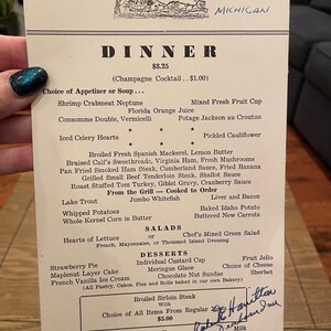 May include: A vintage dinner menu from The Dearborn Inn in Michigan dated October 23, 1952. The off-white paper features black text listing various food items including Shrimp Crabmeat Neptune, Broiled Sirloin Steak, and desserts like Strawberry Pie.