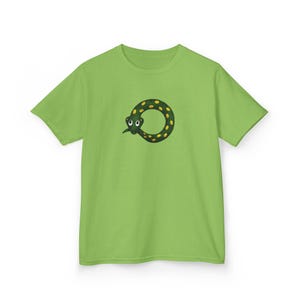May include: A lime green short-sleeve t-shirt featuring a graphic of a dark green snake curled into a circular shape. The snake has yellow spots, white eyes with black pupils, and is positioned in the center of the chest area of the garment.