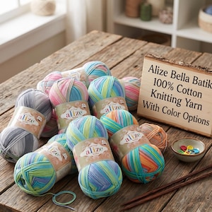Puede incluir: Una colección de ovillos de hilo para tejer Alize Bella Batik 100% algodón en varios patrones multicolores. Cada ovillo tiene una etiqueta de papel con la marca Alize. Un letrero de madera muestra el texto Alize Bella Batik 100% Cotton Knitting Yarn.