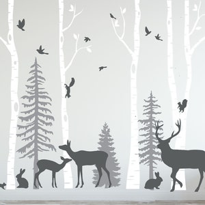 Può includere: Adesivi murali in silhouette che rappresentano una scena di bosco con betulle, pini, cervi, conigli, scoiattoli e uccelli. Gli adesivi sono in tonalità di grigio su uno sfondo bianco.