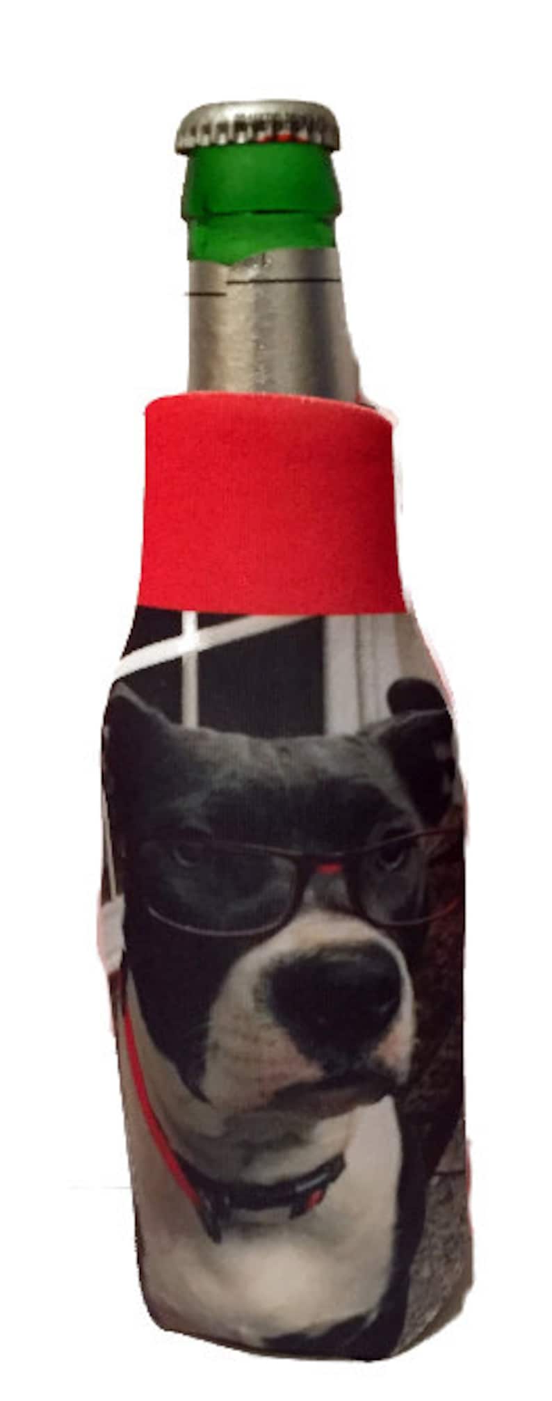 May include: A red and black bottle cooler with a photo of a dog wearing glasses. The dog has black and white fur and is looking at the camera.