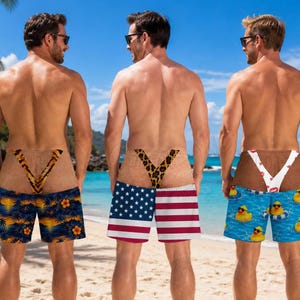 May include: Three pairs of swim trunks featuring a realistic skin-tone print on the upper portion with a thong-style design. The first pair has a tropical sunset pattern, the second features the American flag, and the third shows yellow rubber ducks.