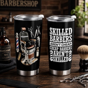 Puede incluir: Dos vasos de acero inoxidable negro con tapas transparentes. Uno muestra una silla de barbero con el nombre Thomas, un poste de barbero y herramientas. El otro muestra el texto blanco: SKILLED BARBERS AREN'T CHEAP, CHEAP BARBERS AREN'T SKILLED.