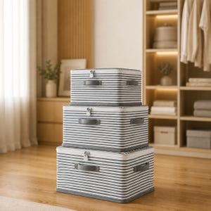 May include: A stack of three rectangular storage bins featuring a grey and white horizontal striped pattern. Each bin includes a zippered lid, a top handle, and side handles, with the containers arranged from smallest at the top to largest at the base.