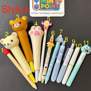May include: A collection of eleven stylus pens featuring various designs including bear heads, a cat paw, a star wand, and cartoon characters. Each stylus is numbered from 1 to 11, with diverse colors like brown, cream, blue, and white, displayed alongside a Mint Point Gaming logo card.