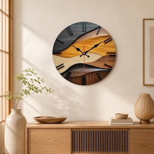 May include: A circular wall clock featuring layered, wavy wooden panels in shades of black, dark brown, light brown, and natural tan. The clock face has black hour markers and black hands, with a thin red second hand centered on the dial.