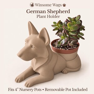 May include: A matte beige German Shepherd plant holder with a removable brown pot containing a green succulent. The text reads Winsome Wags, German Shepherd Plant Holder, and Fits 4" Nursery Pots • Removable Pot Included.
