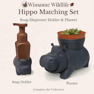 May include: A matching set featuring a hippo-shaped soap dispenser holder and a planter. The soap dispenser holder is brown, and the hippo base is dark gray. The planter, also hippo-shaped, holds a small plant in a brown pot. The text reads "Winsome Wildlife Hippo Matching Set".