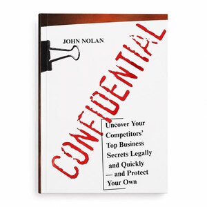 May include: A book titled Confidential by John Nolan with a black binder clip on the left edge. The cover features the word CONFIDENTIAL in large red letters and the subtitle Uncover Your Competitors' Top Business Secrets Legally and Quickly.