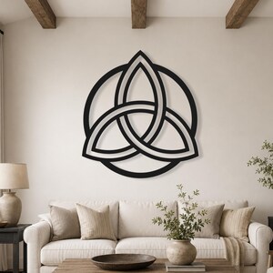 May include: A black metal wall art piece featuring a triquetra symbol enclosed within a circular frame. The design consists of three interconnected, pointed oval shapes that form a continuous, symmetrical pattern with clean, bold lines.