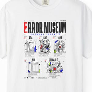 Puede incluir: Una camiseta blanca de manga corta con un estampado gráfico titulado ERROR MUSEUM SOFTWARE ENGINEER. El diseño incluye cinco iconos de errores técnicos etiquetados 404, 500, 403, NULL y SEGFAULT, cada uno con dibujos lineales y texto.