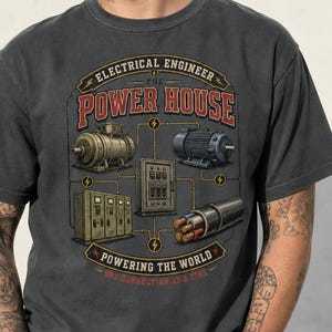 Könnte beinhalten: Ein anthrazitfarbenes T-Shirt mit einem Grafikdruck von elektrotechnischen Geräten, darunter Motoren, ein Schaltschrank und Kabel. Der Text lautet: ELECTRICAL ENGINEER THE POWER HOUSE POWERING THE WORLD ONE CONNECTION AT A TIME.