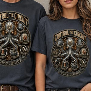 Könnte beinhalten: Ein anthrazitfarbenes T-Shirt mit einer kreisförmigen Grafik und dem Text "CONTROL THE CIRCUIT" sowie "ELECTRICAL ENGINEER". Das Motiv zeigt einen metallischen Kraken, der von verschiedenen elektrischen Bauteilen wie Schaltern und Spulen umgeben ist.