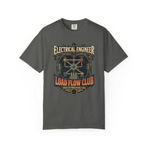 Può includere: Una t-shirt grigio antracite a maniche corte con una stampa grafica recante il testo Electrical Engineer Load Flow Club. Il design include uno schema di linee elettriche, tralicci e nodi colorati in blu, rosso e giallo.