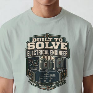 以下が含まれることがあります： BUILT TO SOLVE ELECTRICAL ENGINEERというテキストがデザインされた、ライトセージグリーンのTシャツ。イラストには、変圧器、回路遮断器、三相波形図、そしてDESIGN、ANALYZE、TEST、SOLVEという単語が含まれています。