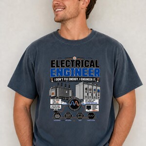 May include: A dark blue short-sleeve t-shirt featuring a graphic print with the text Electrical Engineer I Don't Fix Energy. I Engineer It. The design includes illustrations of a transformer, switchgear, and relay, along with technical icons.