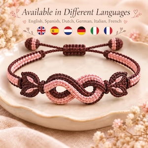 Puede incluir: Una pulsera de cordón trenzado con un diseño central de símbolo de infinito en marrón oscuro y rosa claro. La pulsera incluye nudos deslizantes ajustables con extremos esféricos y detalles en forma de hoja a cada lado del lazo de infinito.