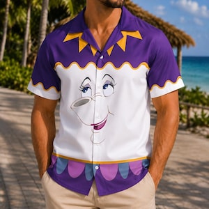 Può includere: Una camicia a maniche corte con bottoni, colletto viola con accenti triangolari gialli, sezione centrale bianca che mostra un volto di cartone animato con occhi blu e un sorriso, e orlo viola con un motivo smerlato in blu.