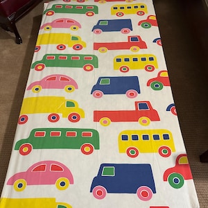 以下が含まれることがあります： カラフルな乗り物のパターンが特徴の白いフィットシーツ。デザインには、赤、ピンク、緑、黄色、青の車、トラック、バスが含まれています。シーツは、シングルまたはダブルベッド用である可能性があります。サイズはセンチメートル単位です。