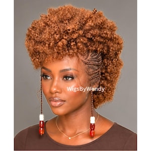 May include: A copper-colored curly wig featuring a mohawk-style silhouette with intricate cornrow braids along the side. The hairstyle includes two long, thin braided strands hanging down the front, each adorned with white and red beads. WigsByWendy.