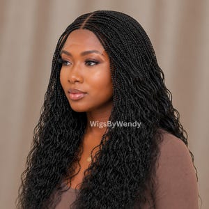 Peut inclure: Une perruque noire à lace front avec de longs cheveux micro-tressés fins et une texture ondulée. Les tresses sont séparées au milieu et descendent au-delà des épaules. Le texte WigsByWendy est visible au centre de l'image.