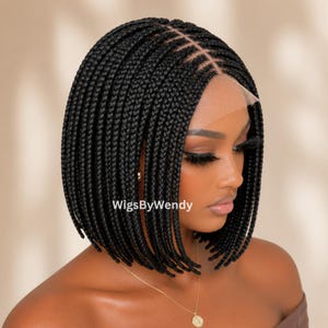 Könnte beinhalten: Eine schwarze geflochtene Bob-Perücke mit Lace-Front-Konstruktion und Mittelscheitel. Das Haar ist zu gleichmäßigen, dünnen, einzelnen Zöpfen geflochten, die bis zum Kinn reichen. Der Text WigsByWendy ist auf dem Haar deutlich zu sehen.