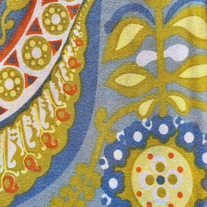 May include: A fabric with a blue, yellow, and orange paisley pattern. The fabric has a repeating pattern of leaves, flowers, and circles.