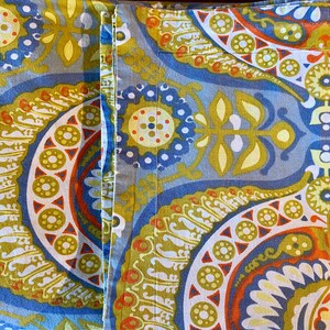 May include: A pair of blue and yellow patterned fabric panels with a paisley design. The fabric has a soft, textured feel and is perfect for crafting projects.