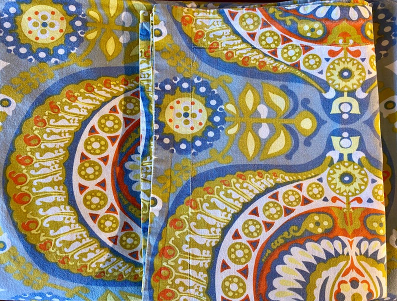 May include: A pair of blue and yellow patterned fabric panels with a paisley design. The fabric has a soft, textured feel and is perfect for crafting projects.