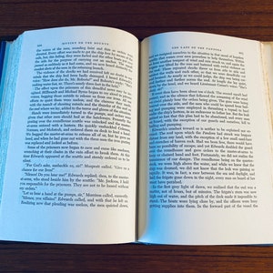 K&ouml;nnte beinhalten: Nahaufnahme von zwei Seiten aus einem Buch mit dem Titel "Mutiny on the Bounty" und "The Last of the Pandora". Die Seiten sind ge&ouml;ffnet, um Text &uuml;ber die Meuterei und die Reise des Schiffes zu enth&uuml;llen. Die Seiten sind gealtert und haben einen abgenutzten, Vintage-Look.