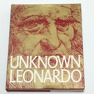 Op de afbeelding: De omslag van het boek "The Unknown Leonardo" heeft een gouden achtergrond met een rode overlay. Op de omslag is een zwart-witte tekening van een mannengezicht te zien. De titel "The Unknown Leonardo" is in witte letters gedrukt.