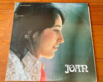 May include: Album cover featuring a woman in profile with dark hair and a floral earring. The album title "JOAN" is in white, stylized lettering. The Vanguard logo is visible, along with the text "STEREO" and "VSD-79840".