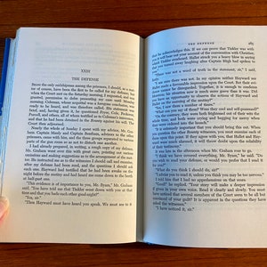 K&ouml;nnte beinhalten: Ein offenes Buch mit wei&szlig;em Hintergrund. Das Buch ist auf einer Seite mit dem Titel "Die Verteidigung" und dem Text "Es war kein Wort der Wahrheit in der Aussage, Sir." Die n&auml;chste Seite hat den Titel "Die Verteidigung" und den Text "Ich habe es bemerkt, Sir."