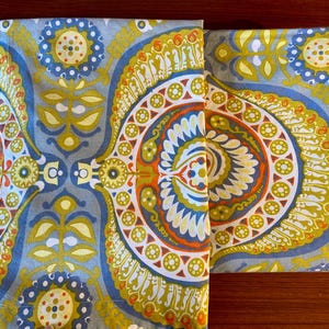 May include: Two fabric panels with a blue, green, yellow, orange, and white paisley pattern. The panels are sewn together along the top edge.