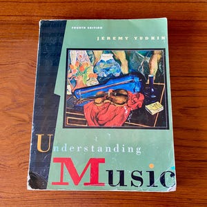 May include: A textbook titled "Understanding Music" by Jeremy Yudkin, Fourth Edition. The cover is green with the title in red and black. An illustration of a violin, case, and still life is featured.
