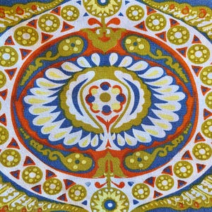 May include: A colorful, circular pattern with a blue, orange, and yellow color scheme. The pattern features a central design with a flower-like shape and repeating geometric shapes around the edges.