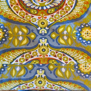 May include: A blue and yellow patterned fabric with a paisley design. The fabric features a repeating pattern of circles, leaves, and swirls.