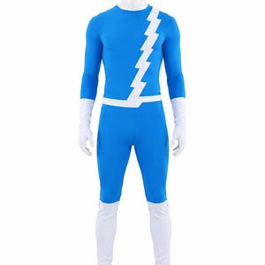 Op de afbeelding: Een felblauw jumpsuit voor het hele lichaam met een witte bliksemschicht-afbeelding die diagonaal over de borst loopt en rond de taille wikkelt. Het kledingstuk heeft lange mouwen, witte handschoenen en witte overschoenen tot halverwege de kuit.
